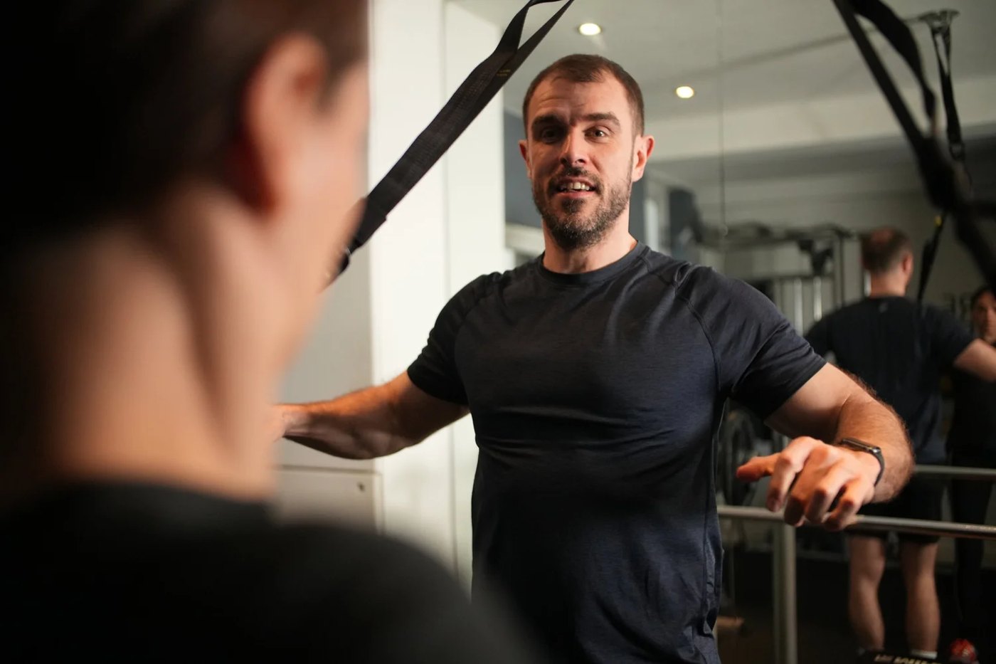 Matthew coaching a client on TRX suspension straps